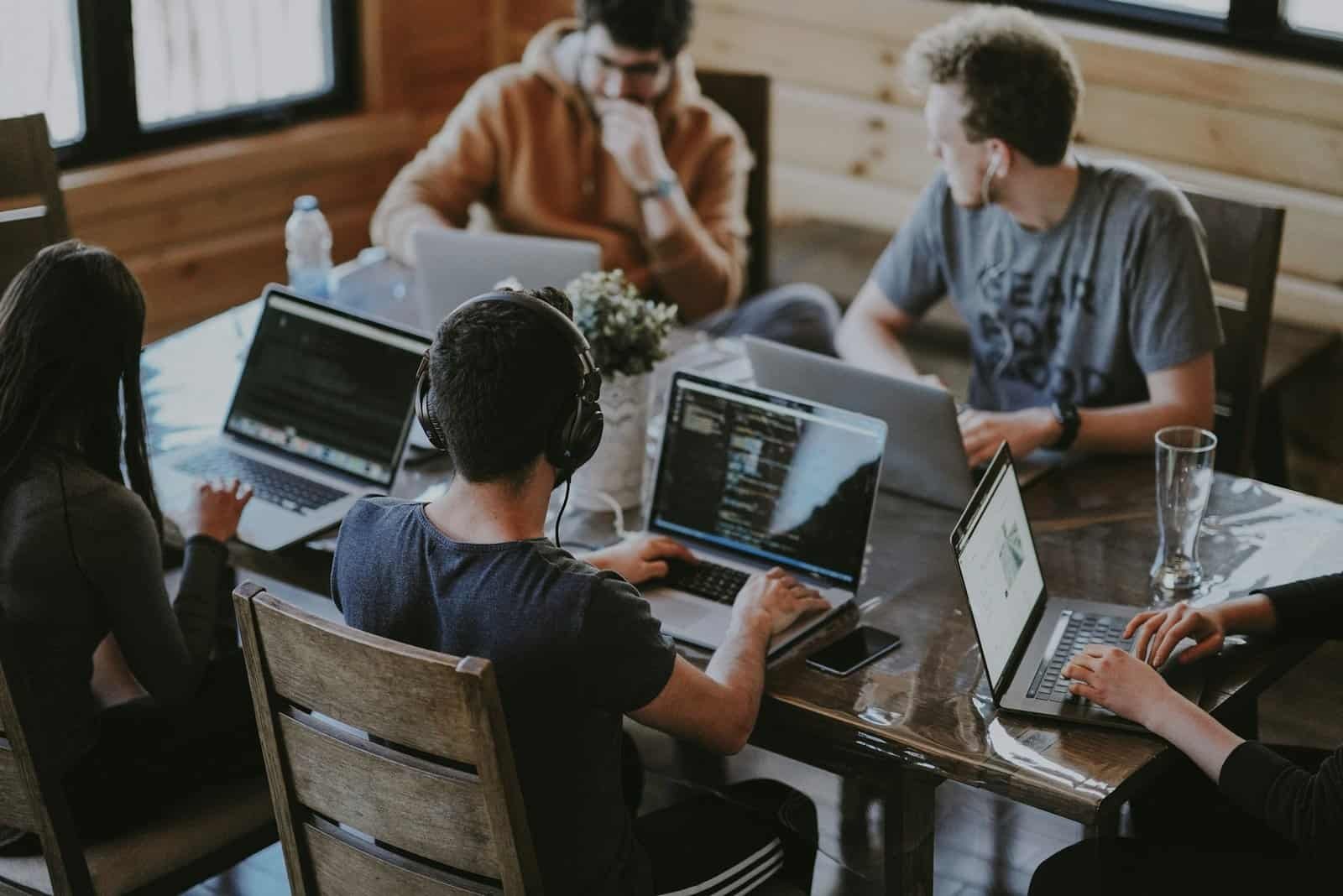Team collaborating around laptops in a modern workspace
