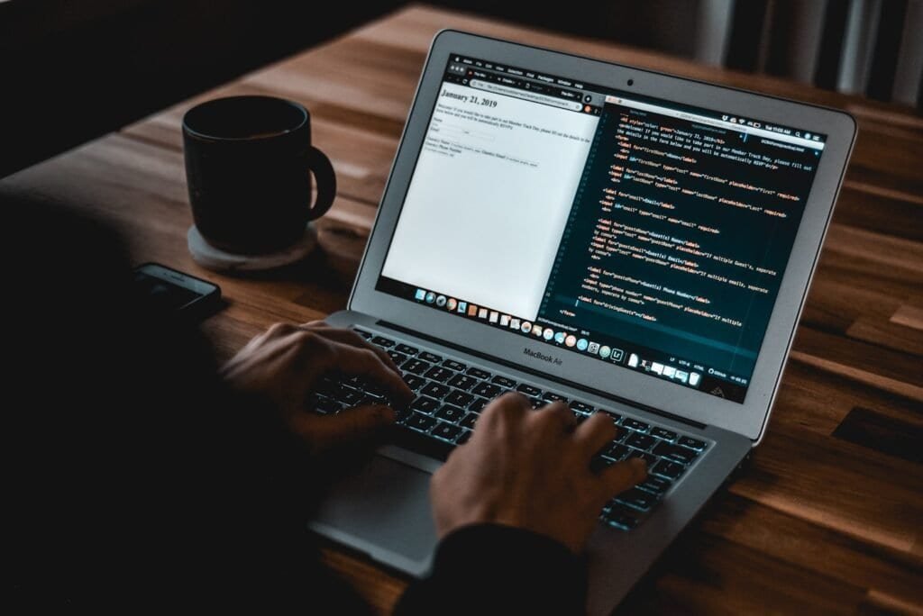 Developer coding a website on a laptop